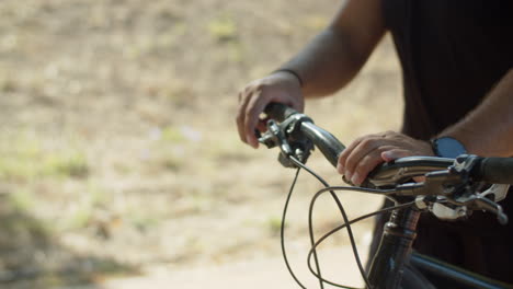 close-up shot of mans hands holding handlebar of bicycle