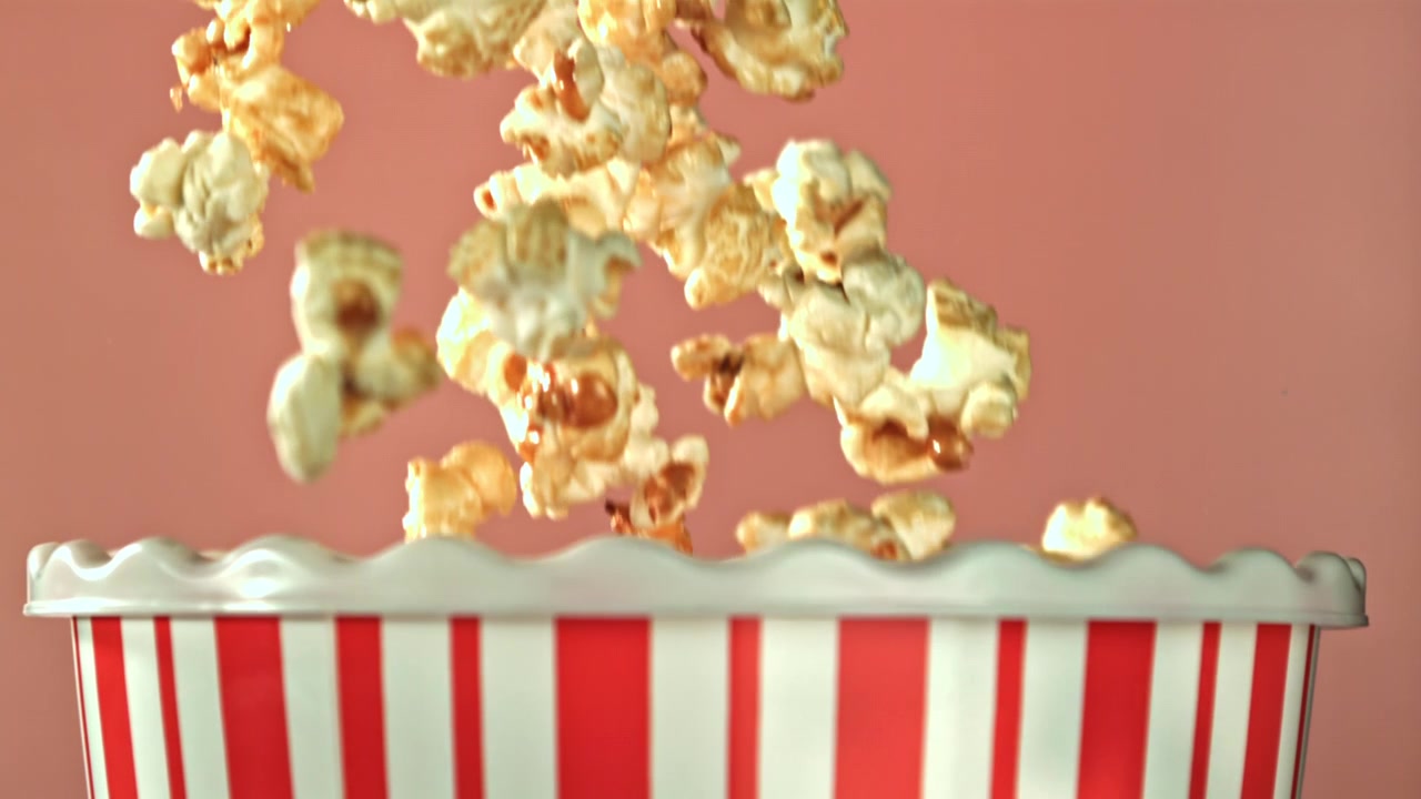 Chicchi di popcorn che cadono in slow motion in un secchiello di popcorn