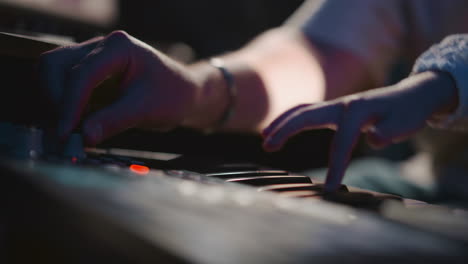 mentor supervises sound of synthesizer. educator organizes musical apparatus for learner. child hand presses keys playing. musical knowledge for little girl