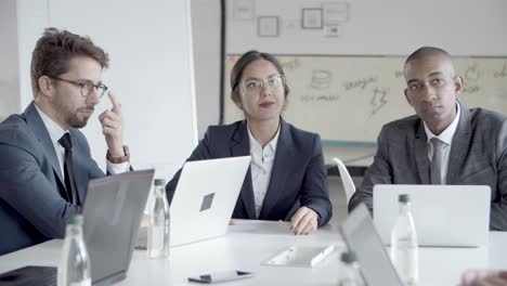 group of confident analysts communicating during meeting