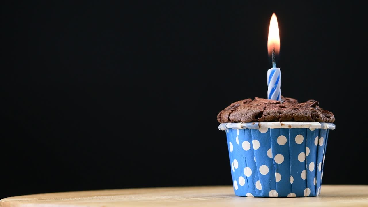 fiesta de pasteles con vela en fondo azul cinemagraph bucle sin costuras.