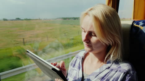 a young woman travels by bus uses a tablet