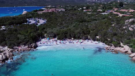 Packed-summer-Spiaggia-del-Pirata-Capriccioli-beach-Lido-Italy-aerial