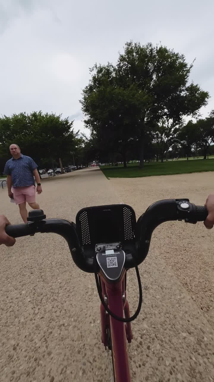Visão em Primeira Pessoa de Andar de Bicicleta por um Parque Urbano