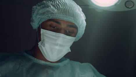 Focused-surgeon-performing-surgical-operation-in-intensive-care-unit-portrait.