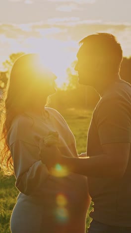 pregnant couple at sunset