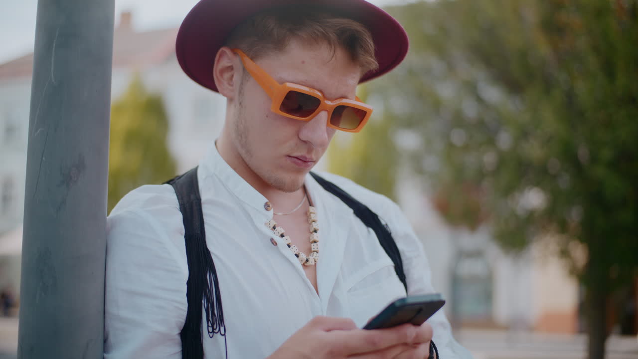 밖에서 스마트폰을 사용하는 스타일리시한 남자