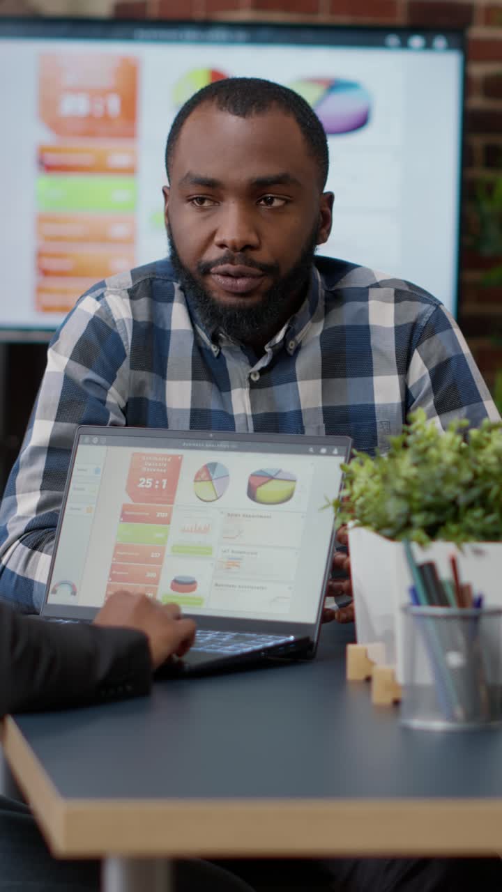 Business meeting with data presentation on laptop