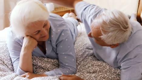 senior couple interacting while relaxing on bed