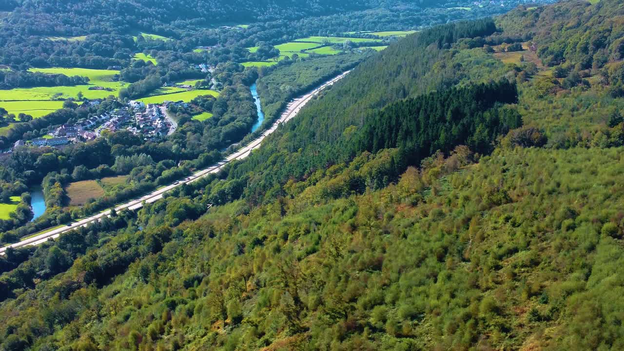 Sideways Aerial with Hiking Gravel Track Adjacent to Busy Welsh Dual Carriageway Road with River Neath and Small Housing Estate. Nature Drone Clip