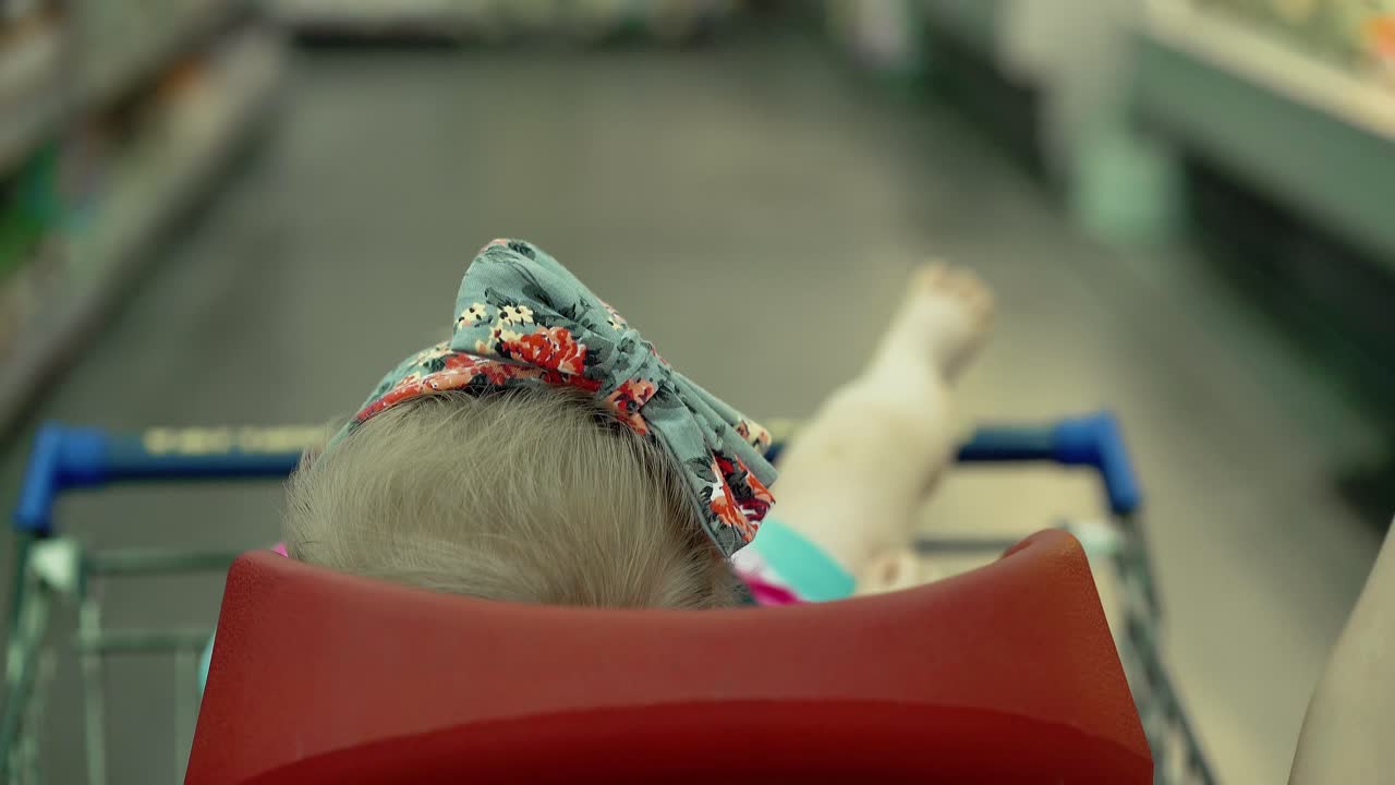 아이 는 슈퍼마켓 2 에서 특별히 장착 된 의자 6 에 앉아 있다