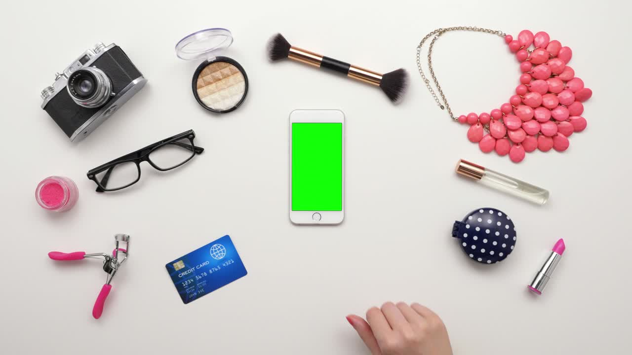 신용카드와 화장품으로 스마트폰을 만지는 여성의 상단 시각