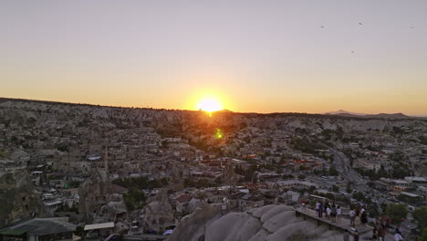 göreme turquía aérea v30 bajo sobrevuelo panorámico punto de vista de la puesta de sol en una meseta alta a través de la antigua ciudad del pueblo capturando la puesta de sol dorada brillante en el horizonte - filmada con el cine mavic 3 - julio de 2022