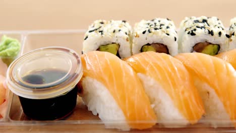 rollos de sushi con salmón en un recipiente de plástico