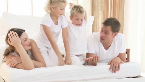 Happy-young-family-playing-in-bed