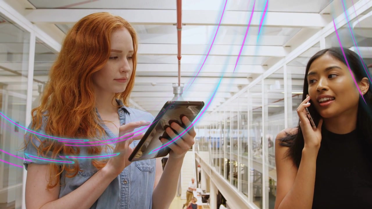 Redhead woman using work tablet at glass rail, peer walking on phone, sparking trails animating hub
