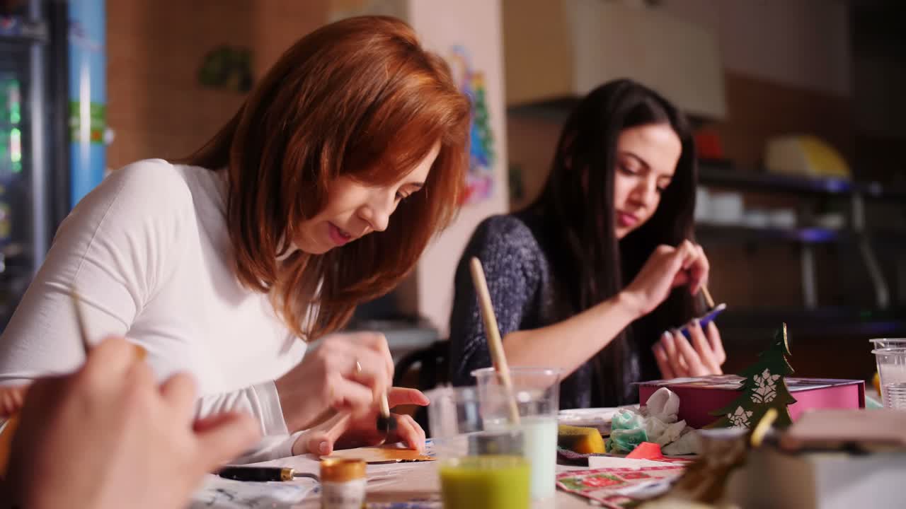 Women crafting and painting Christmas decorations