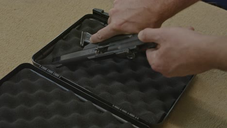 man safely taking pistol from briefcase, checking if the gun is clear and placing a chamber flag