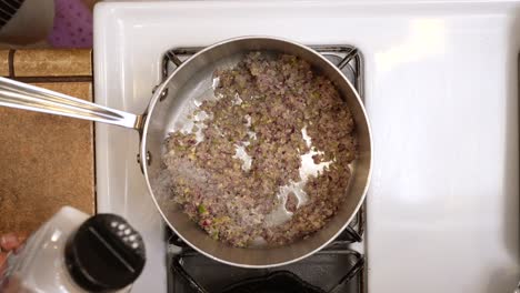 sprinkling salt into ground caramelized onions and vegetables - top down chana masala series