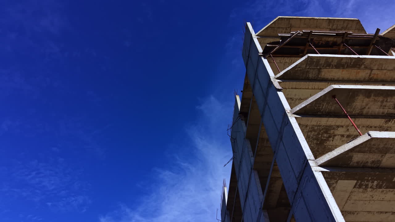 Concrete structure rising against a clear blue sky reveals impressive architecture and urban development at midday