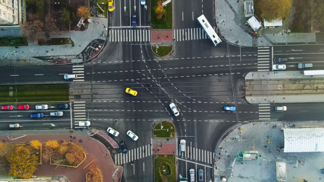 Crossroad with moving cars, bare trees and residential buildings, fog above the ground, view from a drone, Bucharest, Romania