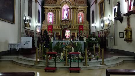 church interior with ornate altar, pews, and christmas decorations