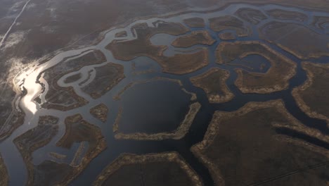 backward aerial view of shaped engures lake islands with reflection