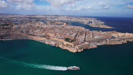 Alto-Paisaje-Aéreo-Del-Ferry-Rápido-De-Gozo-Saliendo-De-La-Valeta,-Malta.