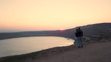 couple-sitting-on-the-edge-on-sunset