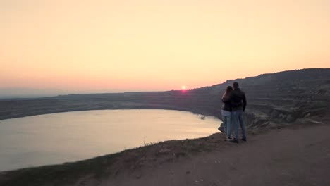 pareja sentada en el borde al atardecer