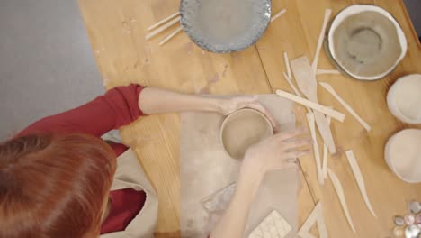 Female Artisan Smoothing Inner Surface of Clay Bowl with Thumb