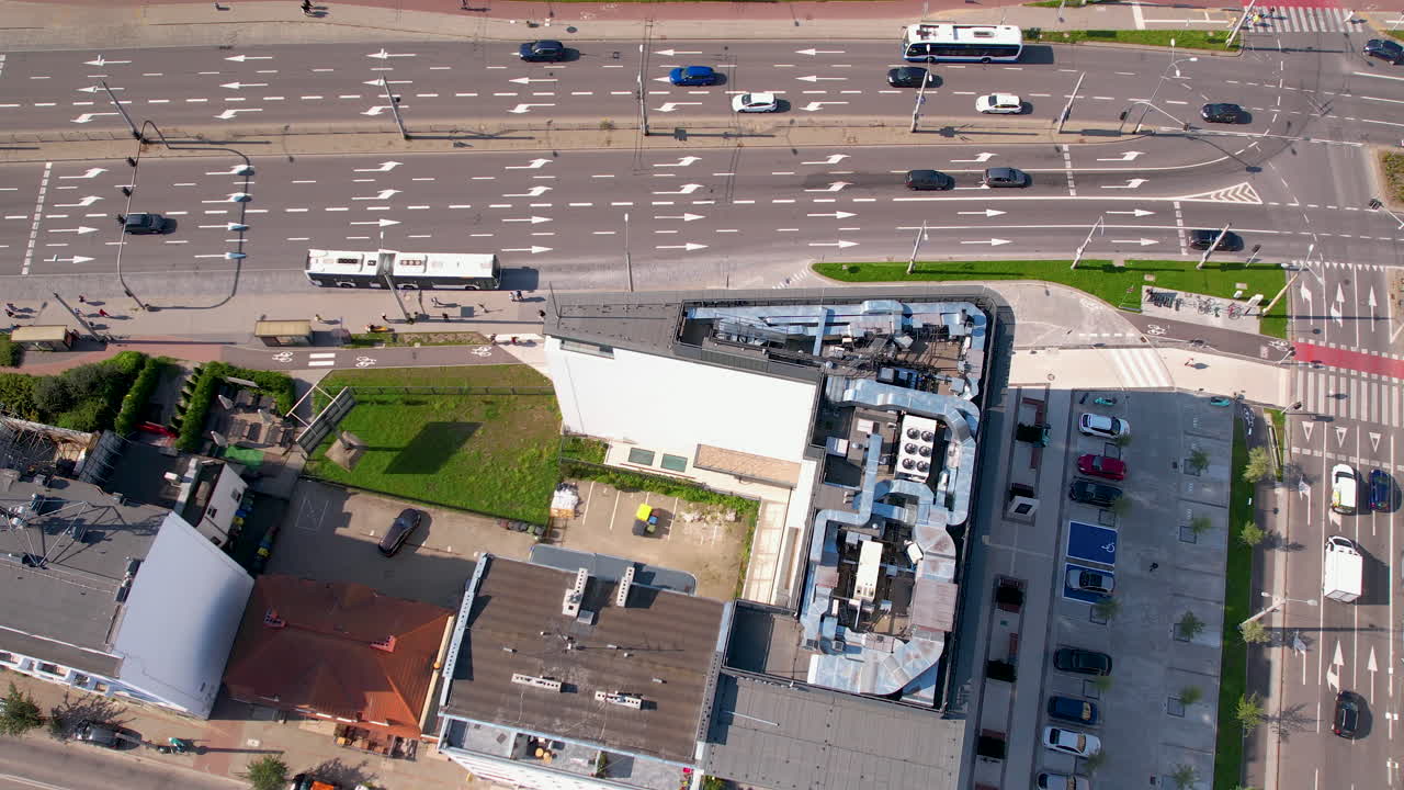 vista alta del avión no tripulado de la intersección de la carretera de la ciudad junto al edificio de baja altura 4k