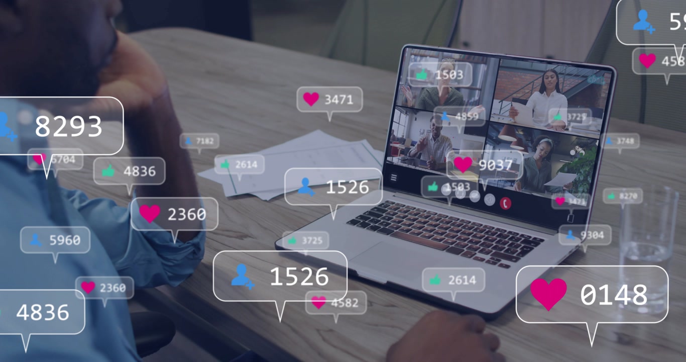 Seated man tracking incoming reactions in meeting, hearts and counters circling laptop then fading
