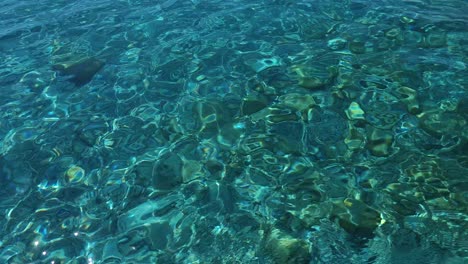 la luz del sol reflejada en el agua de mar de esmeralda limpia en la orilla con guijarros, hermoso fondo de relajación en las vacaciones de verano