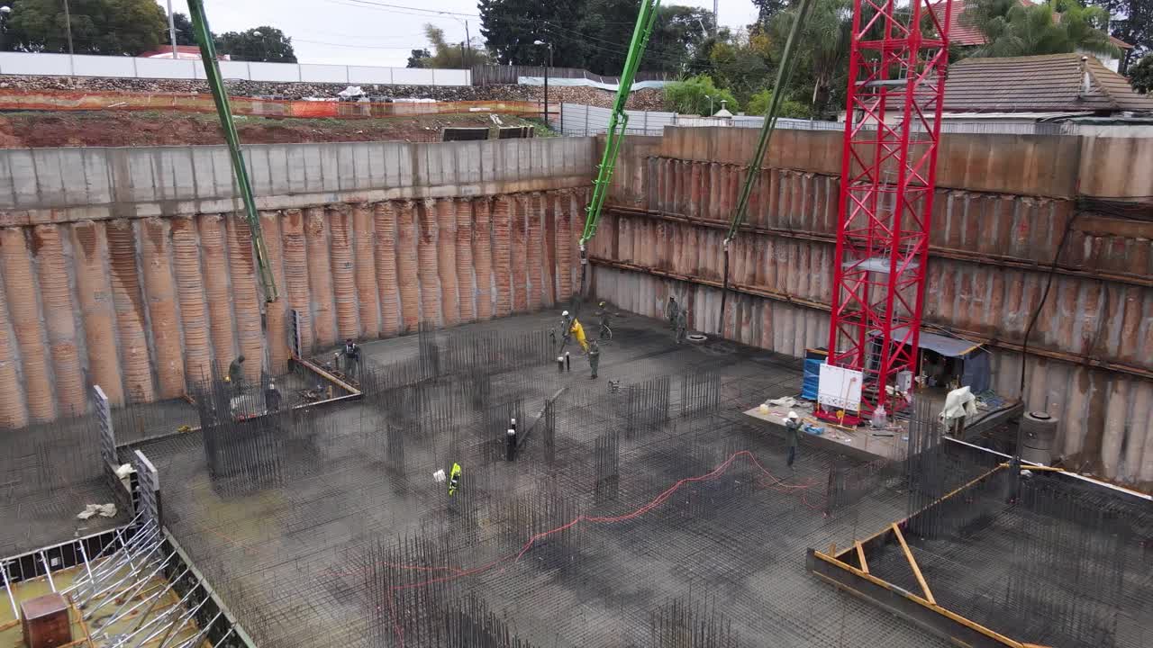 vista aérea de los trabajadores de la construcción que colocan cemento usando una bomba automática, israel