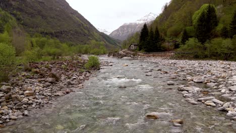 vuelo de avión no tripulado en el valle de verzasca sobre un río claro salvaje