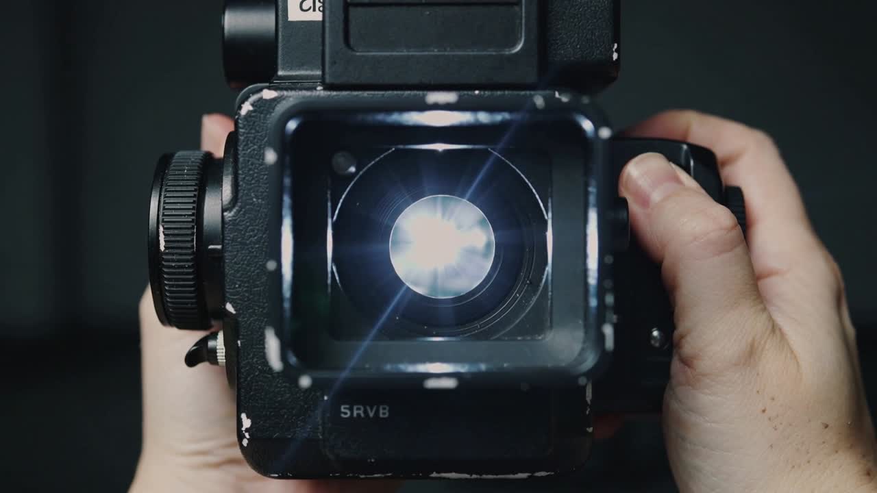 Kameraoperatør holder et SRV8-rig, drejer knap, lampe belyser iris og skaber stjerneglimt til film.