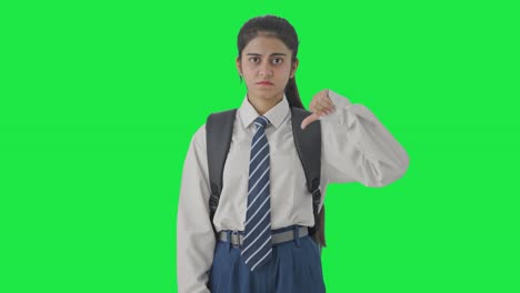 niña de escuela india decepcionada mostrando los pulgares hacia abajo pantalla verde