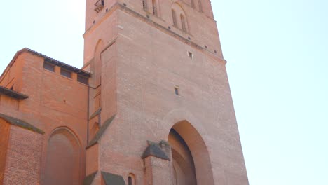 woman walking in front of basilica of saint-sernin in toulouse, france. - tilt up shot