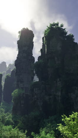 Majestic rock formations rise above lush greenery under a bright sky