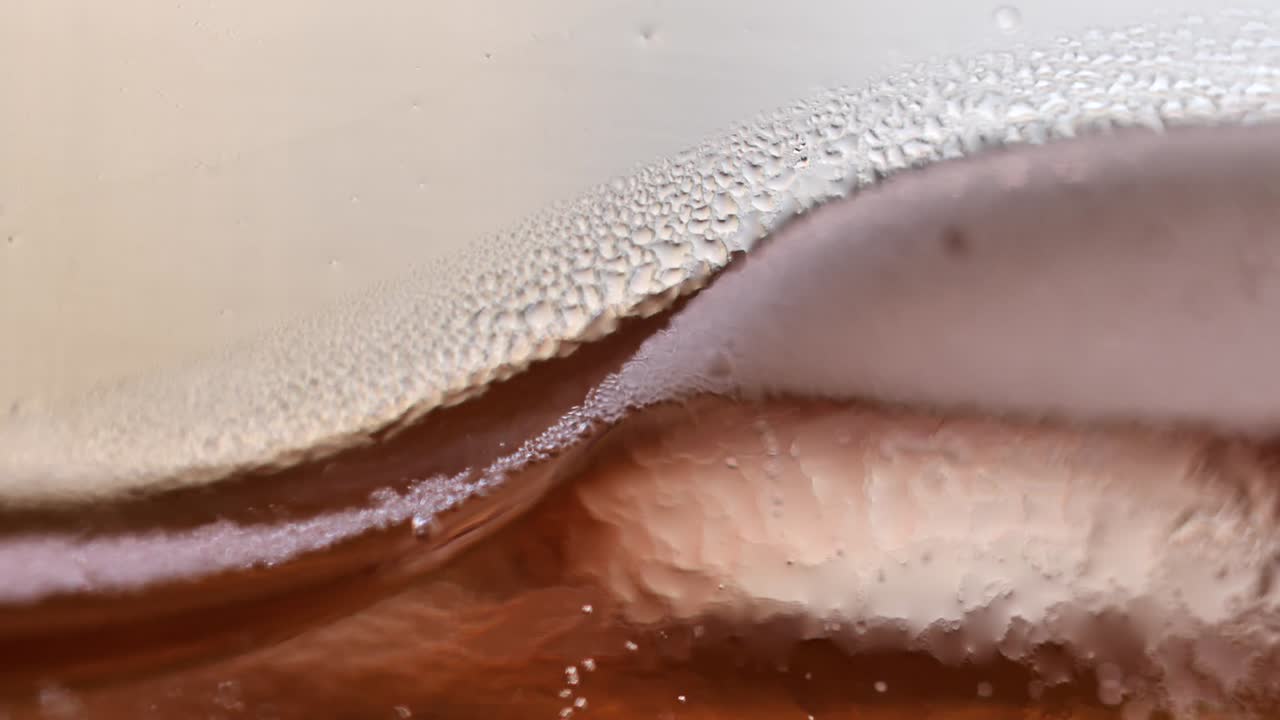 아이스 티의 추상 매크로 근접 촬영 질감, 유리에 상승하는 가스 거품, 핸드헬드