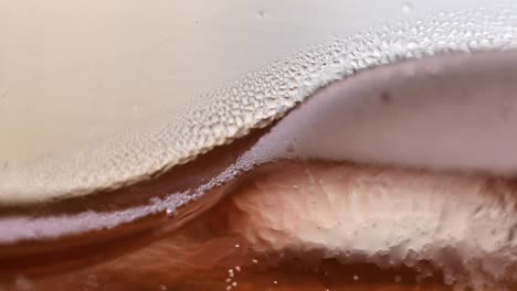 abstract macro closeup texture of ice tea, rising gas bubbles in glass, handheld