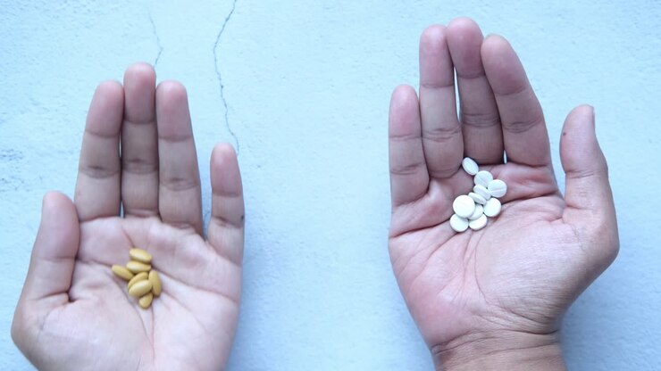Hands holding different colored pills
