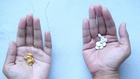 hands holding different colored pills