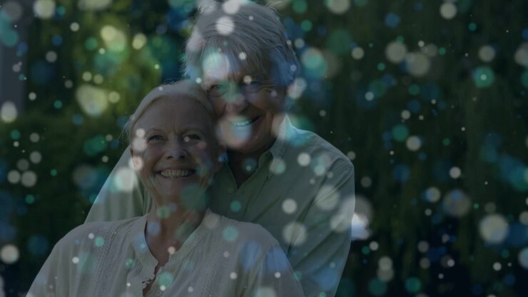 Senior couple posing yard romance, woman turning toward him leading him nuzzling, bokeh drifting