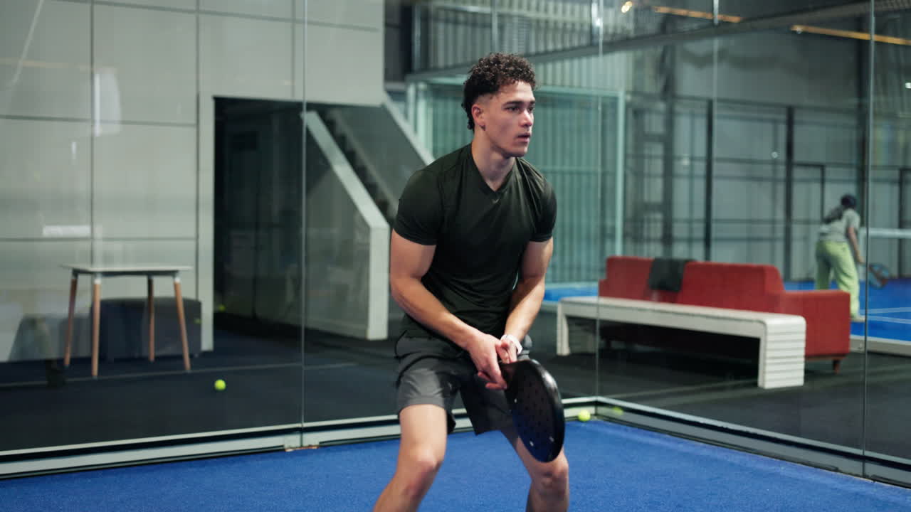Man playing padel tennis indoors