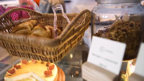 bakery display case with croissants and cakes