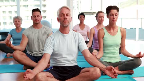 Yoga-class-sitting-in-lotus-position-together