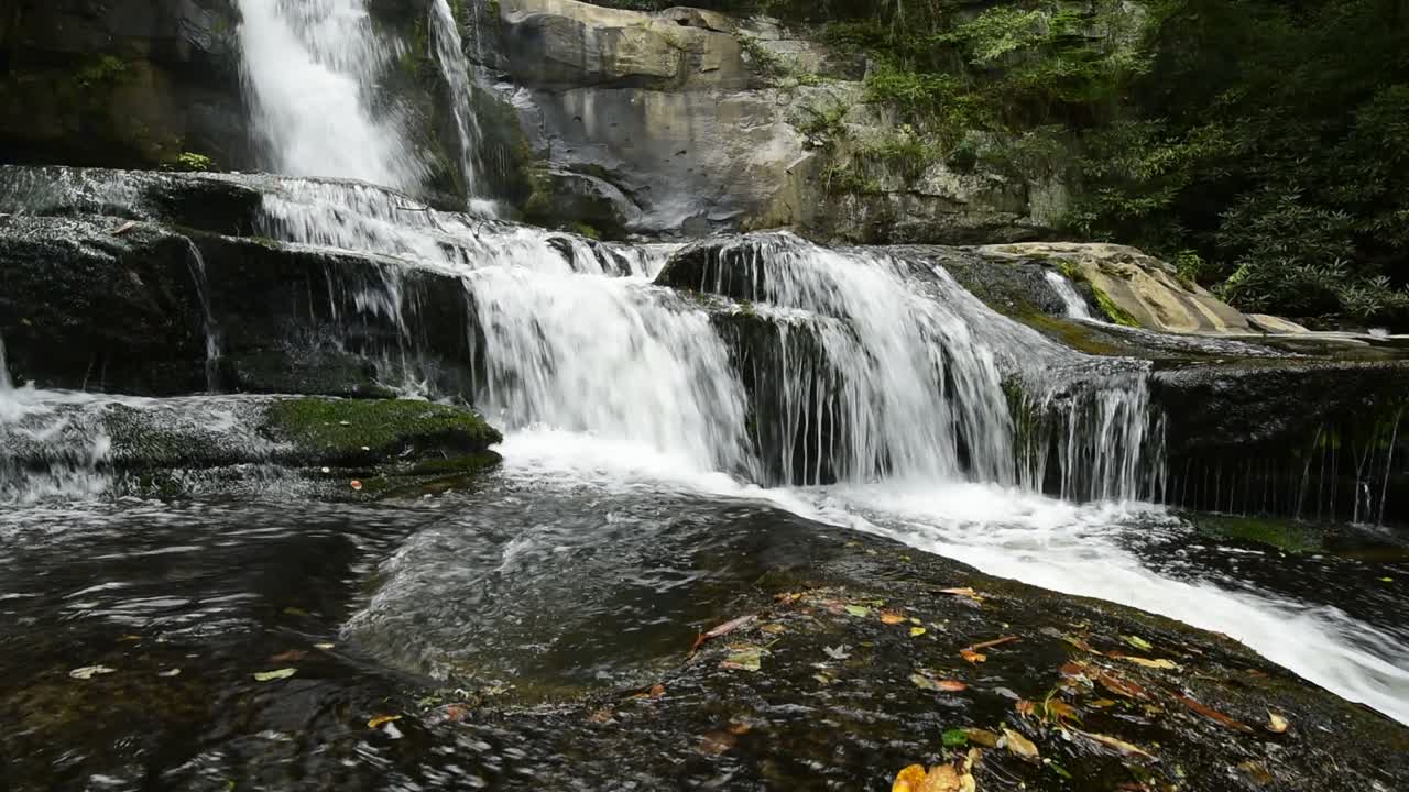 Idyllischer Wasserfall, der den Berghang hinab und über Granitfelsen fließt