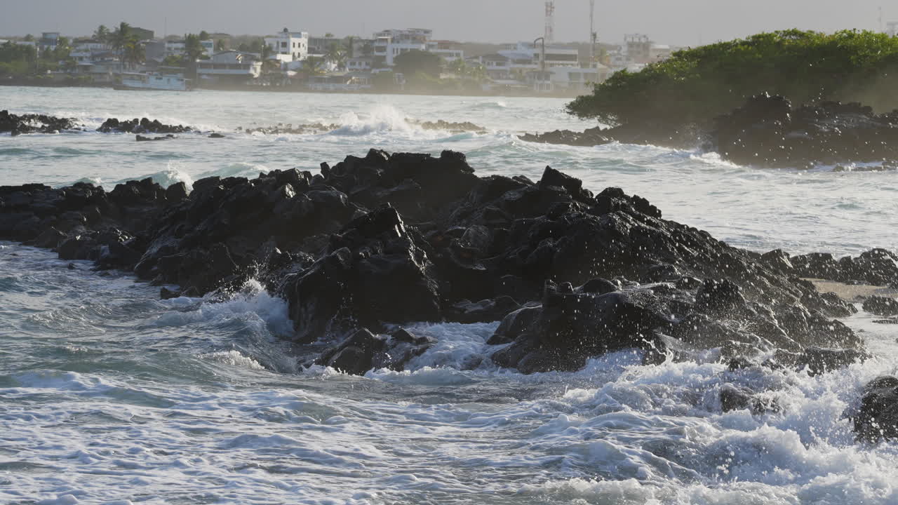 Dramatic Ocean Waves Breaking Onto Rocks At Playa de la Estacion In The Galapagos. Slow Motion